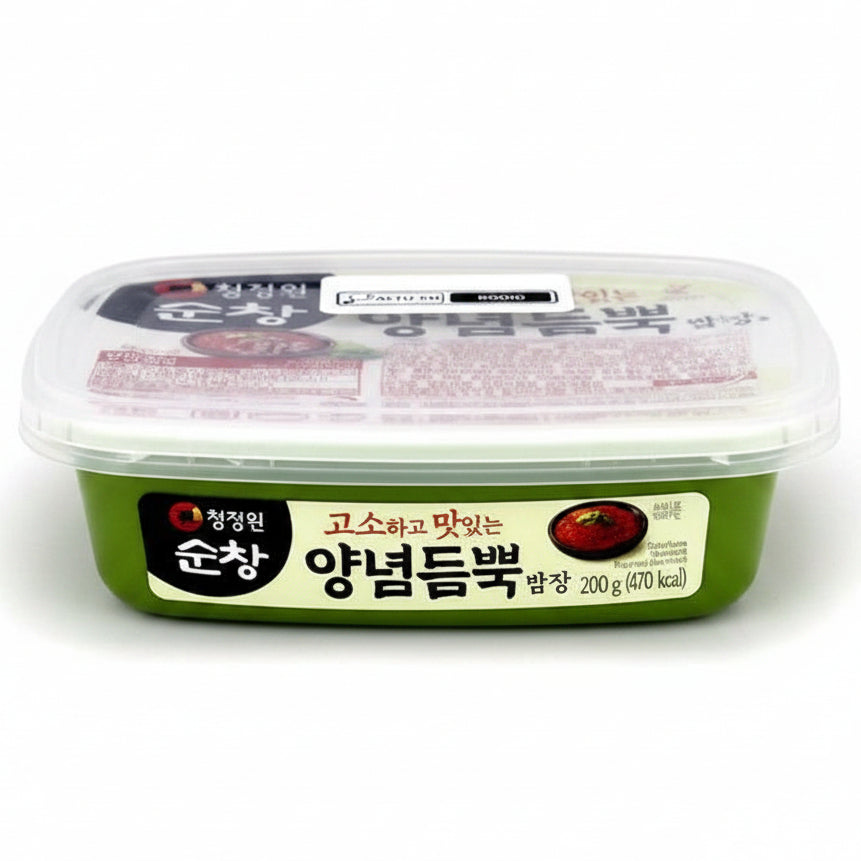 A container of Korean food, specifically Yangnamdumppok (pickled red cabbage), in a green plastic tub with a clear lid. The packaging features a white and green label with Korean text and a red cabbage illustration.