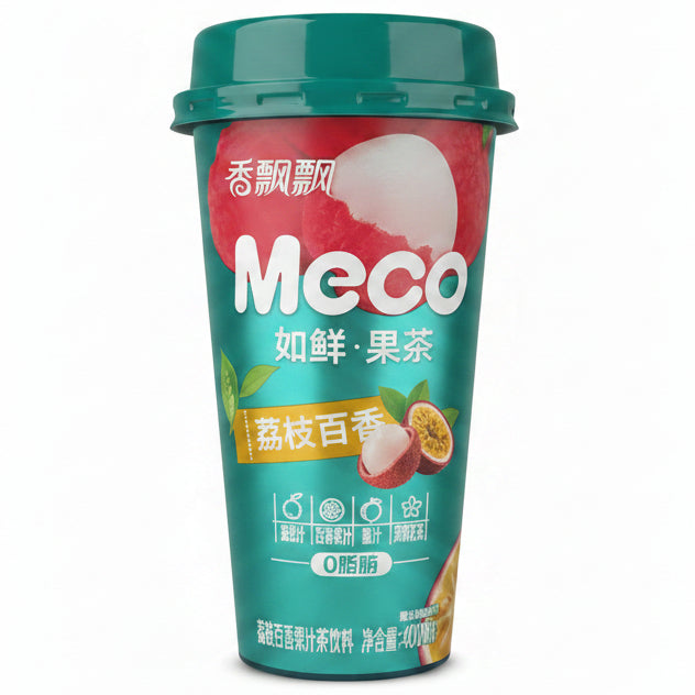 A hand holding a can of Meco 如鲜果茶 (grapefruit tea) on a wooden desk with office items in the background.