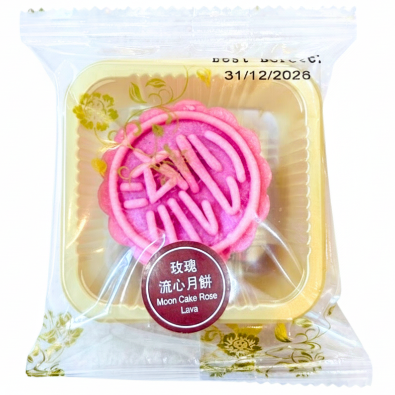 A packaged pink moon cake in a clear plastic bag with gold floral decoration. The cake has a scalloped pink edge and a large pink Chinese character '精' in the center.