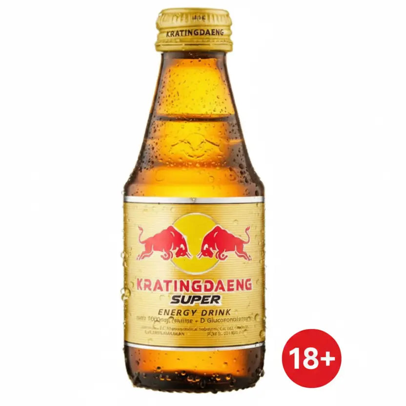 A bottle of Kratingdaeng Super Energy Drink with a gold cap and a gold label featuring the red bull logo, shown against a plain white background.