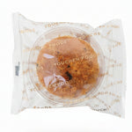 Hand holding a packaged cookie with 'Youcher Foods' branding in a store setting.