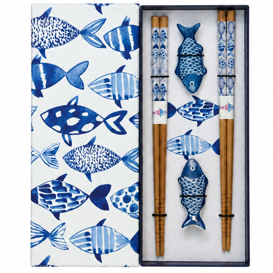 A boxed chopstick set with a white lid patterned in blue fish, shown open to reveal natural wood chopsticks and matching chopstick rests decorated with blue fish motifs.